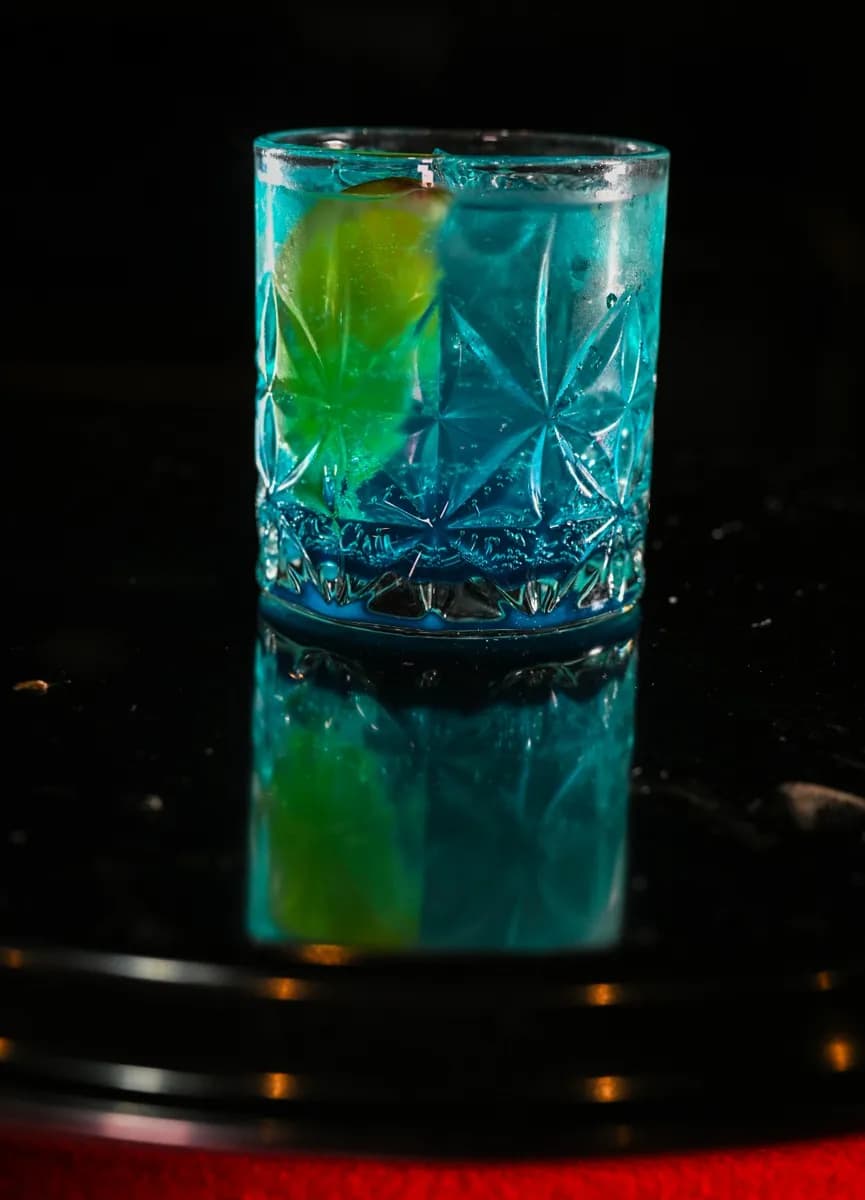 Drink azul com limão em copo lapidado